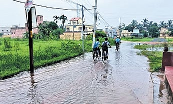 Students going to school on waterlogged road at Jagannath Vihar near Gopalpur in ward no.57.