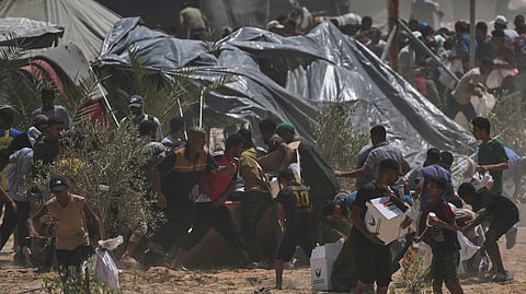 Palestinians rush to collect humanitarian aid packages from the United Arab Emirates, airdropped by parachutes into Deir al-Balah, in the central Gaza Strip.