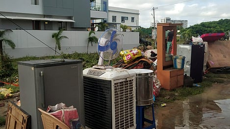 Flood victims clean their houses with the help of NDRF and SDRF teams at GR Colony in Kamareddy on Friday