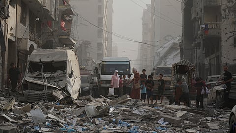 Palestinians stand next to a heavily damaged building in the Rimal neighborhood, in Gaza City, Sunday, Aug. 31, 2025, a day after it was hit by an Israeli military strike that killed several people