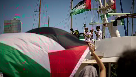 Demonstrators shout slogans on a boat ahead of the launch of a civilian flotilla bound for Gaza, aiming to break the Israeli blockade and deliver humanitarian aid in Barcelona, Spain, Sunday, Aug. 31, 2025.