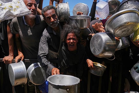Palestinians struggle to get donated food at a community kitchen in Khan Younis, southern Gaza Strip, Monday, Sept. 1, 2025.