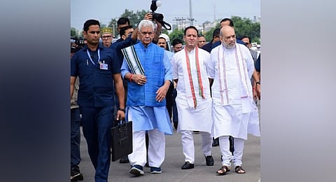 In the pictures, which have gone viral on social media, the CM can be seen watching from behind while Shah is apprised of the damage by Divisional Commissioner Jammu.