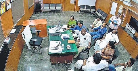 A screengrab of the CCTV footage showing councillor Ramya and others seated and revenue assistant Muniyappan standing behind them.