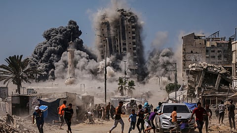 Palestinians run for cover during an Israeli airstrike on a high-rise building in Gaza City, Friday, Sept. 5, 2025, after the Israeli army issued a prior warning.
