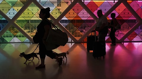 Travelers walk toward an exit at Miami International Airport at the start of the Labor Day weekend, Friday, Aug. 29, 2025, in Miami.
