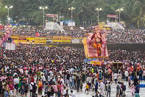 People take part in visarjan, immersion, of idols of Lord Ganesha during the 'Ganesh Chaturthi' festival, at Girgaon Chowpatty, in Mumbai.