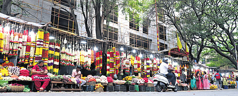 Vendors sell flowers in temporary stalls in front of the upcoming BDA complex on Sampige Road in Malleswaram.