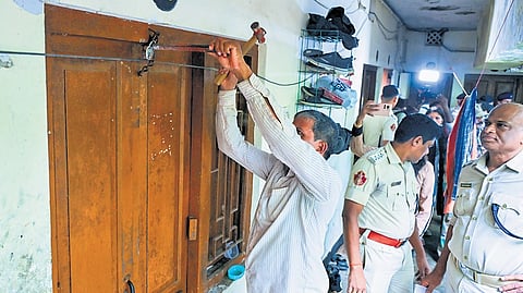 Authorities breaking the lock of a hostel room allegedly occupied illegally at Utkal University, in Bhubaneswar on Monday.