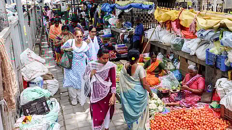 Pedestrians walk alongside vendors who have occupied portions of the pavement on Fort Road near Victoria Hospital on Sunday.