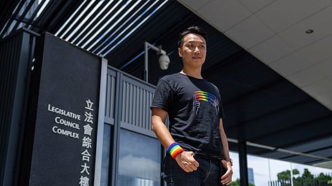 Jimmy Sham, gay rights activist poses for photographs in front of the Legislative Council before the legislative debate on a government bill recognizing same-sex partnerships, a proposed framework stemming from his successful legal challenge at the top court in Hong Kong, Wednesday, Sept. 10, 2025.