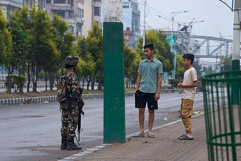 A Nepalese army person checks and question civilians at a checkpoint in Kathmandu, Nepal, Wednesday, Sept. 10, 2025. 