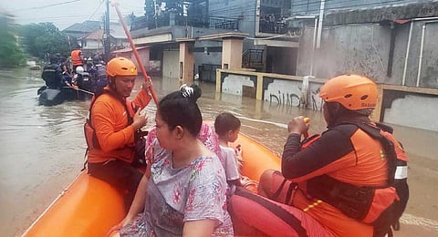 In this photo released by Indonesia's National Search and Rescue Agency (BASARNAS), rescuers on a rubber boat evacuate residents from their flooded home in Denpasar, Bali, Indonesia Wednesday, Sept. 10, 2025.