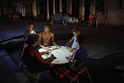 People play dominoes on the street during a blackout in Havana, Wednesday, Sept 10, 2025