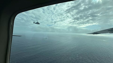 A Chinese military helicopter flies close to a Philippine Bureau of Fisheries and Aquatic (BFAR) aircraft above Scarborough shoal on Tuesday, Feb. 18, 2025.