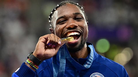 Gold medallist US' Noah Lyles celebrates on the podium during the victory ceremony for the men's 100m athletics event during the Paris 2024 Olympic Games at Stade de France in Saint-Denis, north of Paris, on August 5, 2024.