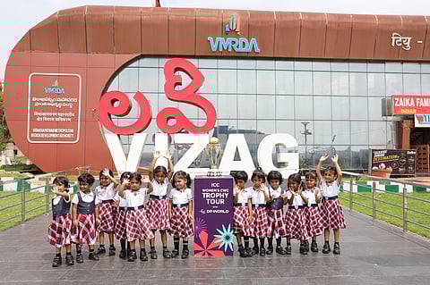 Children pose with the ICC Women's Cricket World Cup 2025 trophy at RK Beach during the Trophy Tour with DP World in Visakhapatnam.