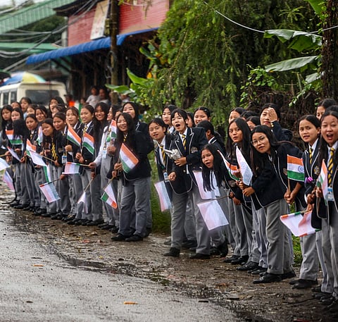 Students welcome Prime Minister Narendra Modi's convoy, in Churachandpur.