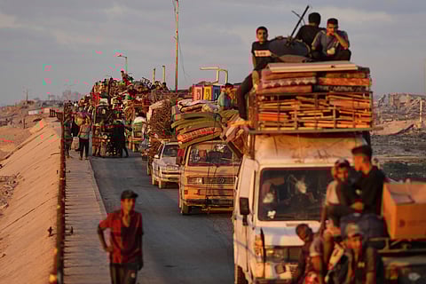 Displaced Palestinians fleeing northern Gaza carry their belongings along the coastal road toward southern Gaza, Thursday, Sept. 11, 2025, after the Israeli army issued evacuation orders from Gaza City.