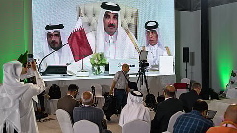 Reporters follow Qatar's Emir Sheikh Tamim bin Hamad Al-Thani's address at the media centre, during the opening of the 2025 Arab–Islamic emergency summit in Doha on September 15, 2025. 