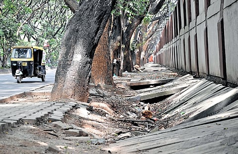Broken slabs on a footpath pose a risk to pedestrians on Varthur Main Road near HAL.