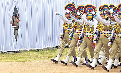 Women police personnel participate in a ceremonial parade while onlookers, including police officials, capture the moment from behind the curtains during the Hyderabad ‘Liberation Day’ celebrations at Parade Ground on Wednesday.