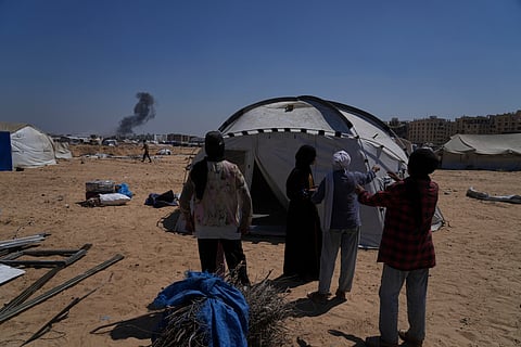 The Abu Jarad family stands in front of their tent in Khan Younis, Gaza Strip, following their displacement from Gaza City, Sept. 11, 2025.