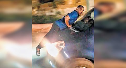 A screengrab from the video showing Kumar clinging on to the car.
