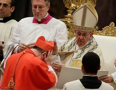 Cardinal Giovanni Angelo Becciu receives the red three-cornered biretta hat from Pope Francis during a consistory in St. Peter's Basilica at the Vatican, June 28, 2018.