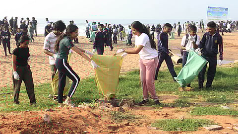 Coast Guard personnel and Andhra University students take part in a coastal clean-up drive on the occasion of International Coastal Clean-Up Day at RK Beach in Visakhapatnam on Saturday.