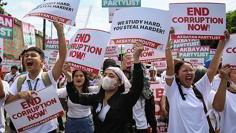 Protesters carry signs as they gather during a rally against government corruption at the EDSA People Power Monument in suburban Mandaluyong, east of Manila, Philippines, Sunday. Sept. 21, 2025.