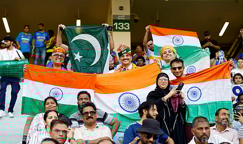  Indian and Pakistani fans holding their national flags pose for a picture before the start of the Asia Cup 2025 match between India and Pakistan at Dubai International Stadium in Dubai on Sept. 14, 2025.