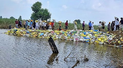 Officials inspect a flood-affected area in a boat, at Ajnala in Amritsar district, Punjab