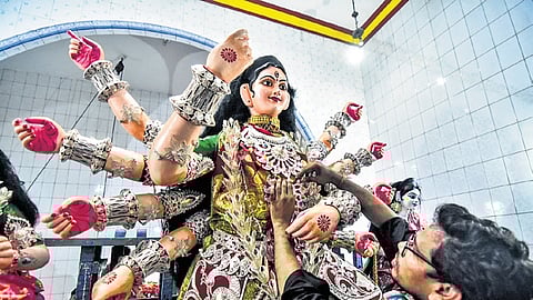 The idol of Goddess Durga at Old Station Bazaar puja pandal in Bhubaneswar being decorated with ornaments, on Wednesday.