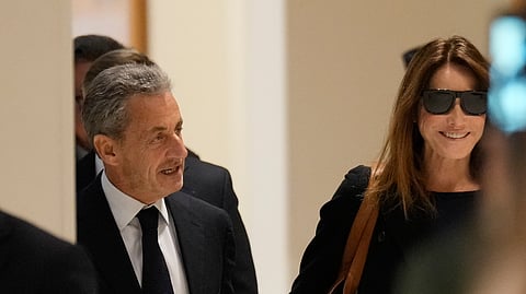 Former French President Nicolas Sarkozy and his wife Carla Bruni Sarkozy arrive to the courtroom for his verdict for alleged illegal financing of his 2007 presidential campaign by the government of then-Libyan leader Moammar Gadhafi, Thursday, Sept. 25, 2025 in Paris.