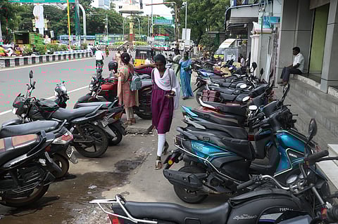 Two-wheelers parked along the pedestrian platform at Indira Gandhi Square in Puducherry force commuters and walkers to step onto the busy main road, creating inconvenience and safety hazards.