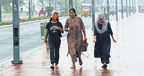 Women walking in the rain in Visakhapatnam on Friday