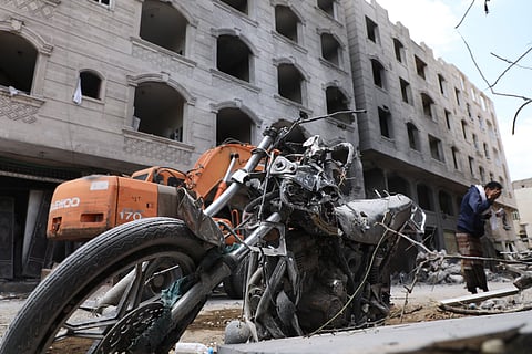 A Yemeni man washes his face next to his damaged motorbike following Israeli airstrikes in Sanaa, Yemen, Friday, Sept. 26, 2025.