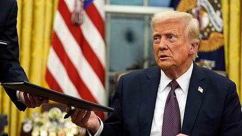 US President Donald Trump signs executive orders in the Oval Office of the White House, in Washington.