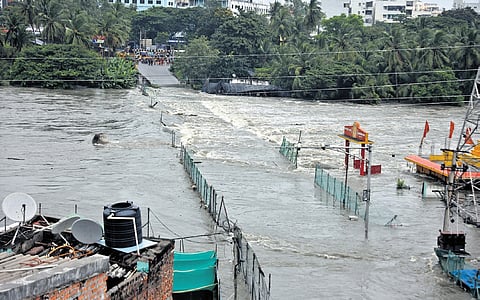 A swollen Musi fully submerges (above) the Chaderghat low bridge while HYDRAA personnel help a stranded passenger out from the flooded MGBS, and left, a drone delivers food to a man stranded atop a flooded building 