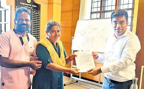 Ramanagara DC Yashwant V Gurukar presents a reward to assistant teacher Shantamma