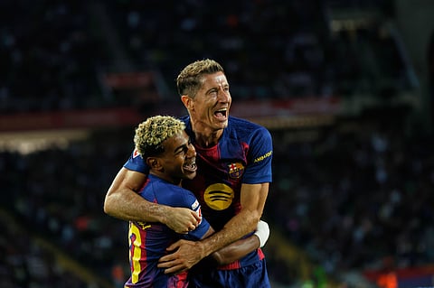 Barcelona's Robert Lewandowski, top, celebrates with Lamine Yamal scoring his side's 2nd goal during a Spanish La Liga soccer match between FC Barcelona and Real Sociedad on Sunday, Sept. 28, 2025. 
