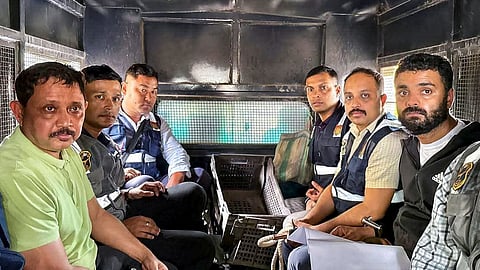 North East India Festival (NEIF) chief organiser Shyamkanu Mahanta and his manager Siddhartha Sharma, alleged to be involved in the death of legendary singer Zubin Garg in Singapore, are brought to the CID office inside a police vehicle following their arrest from Delhi, in Guwahti, Assam, Wednesday, Oct. 1, 2025.