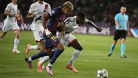 Barcelona's Lamine Yamal is challenged by PSG's Nuno Mendes, right, during the Champions League opening phase soccer match between Barcelona and Paris Saint-Germain on Wednesday, Oct.1, 2025.