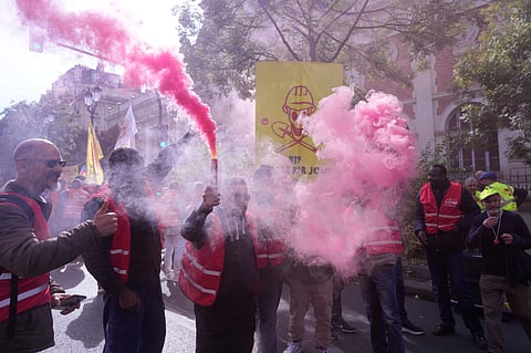 Unionists use flares during a new round of strikes and protests against the caretaker government and cost-cutting Thursday, Oct. 2, 2025 in Paris.