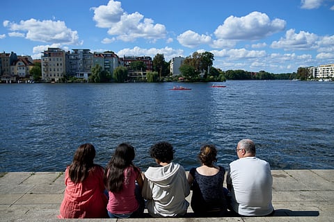 The Wahbeh family, who immigrated to Germany from Syria, sits along a river in Berlin on Aug. 31, 2025.