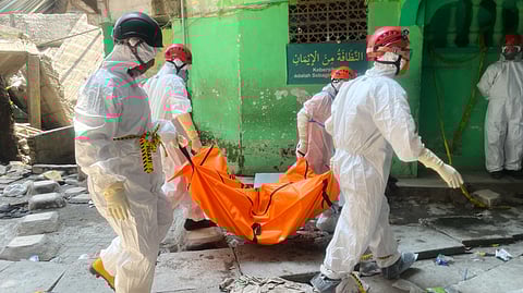 Rescuers carry the body of a victim after an Islamic boarding school collapsed in Sidoarjo, East Java, Indonesia, Friday, Oct. 3, 2025.
