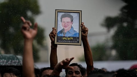 A fan holds a photograph of the popular Bollywood singer and composer Zubeen Garg during the homage ceremony in Guwahati, Sunday, Sept. 21, 2025