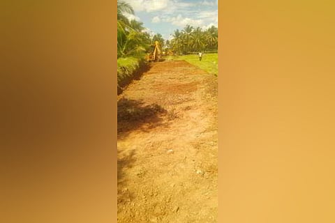 Earthmover paving the path to the burial ground Periyagummanur. 