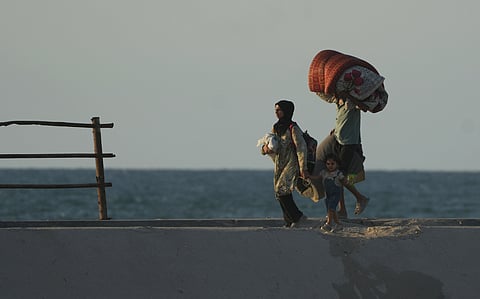 Displaced Palestinians flee northern Gaza carrying their belongings along the coastal road near Wadi Gaza, Thursday, Oct. 2, 2025.
